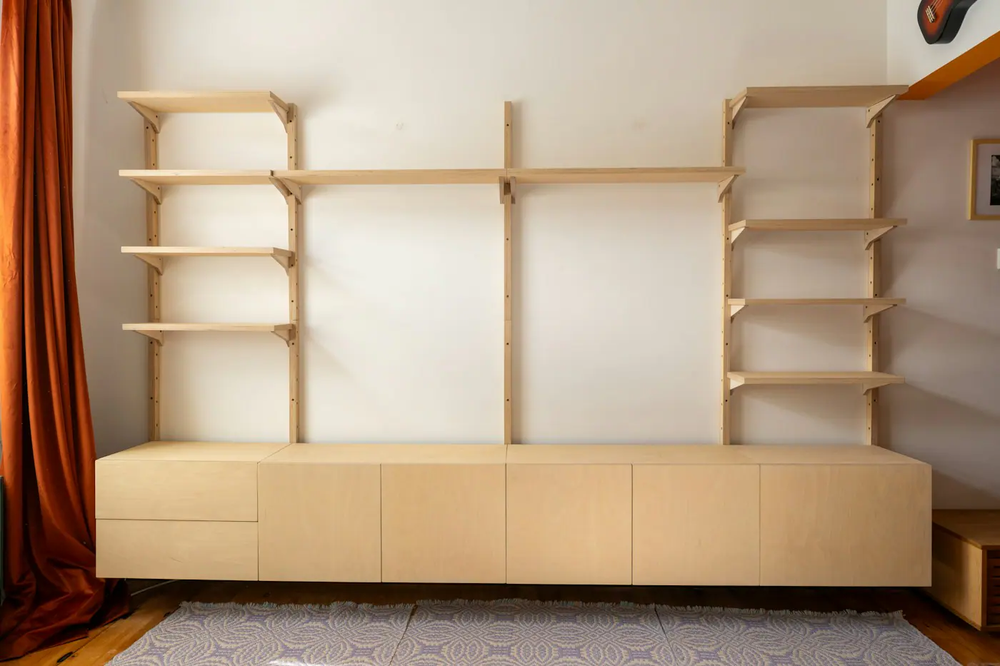 Light wood wall unit with open shelving above a long low cabinet